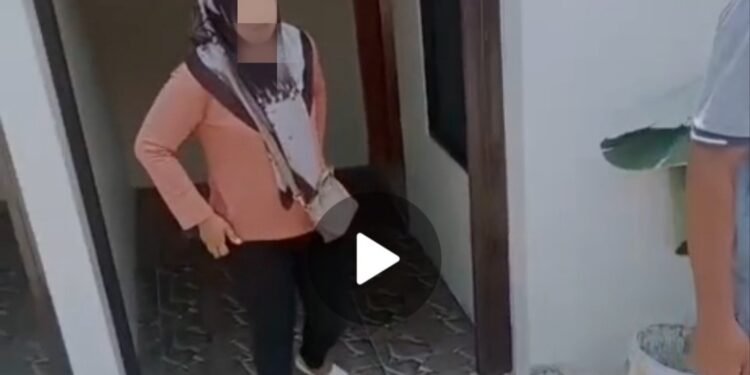 Seorang perempuan terduga oknum Kepala Dusun Crabak, E (kanan), saat berada di depan kamar Hotel yang berlokasi di Giriwoyo, Wonogiri, usai digerebek warga bersama seorang Pria, Selasa (15/9/2026). (Foto: Tangkapan Layar Video Warga/Istimewa)