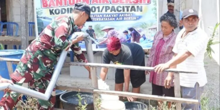 Anggota Kodim 0801/Pacitan bersama warga saat mendistribusikan bantuan air bersih ke wadah penampungan di Desa Punung, Kecamatan Punung, Kabupaten Pacitan, Senin (29/09/2026). (Foto: Istimewa)