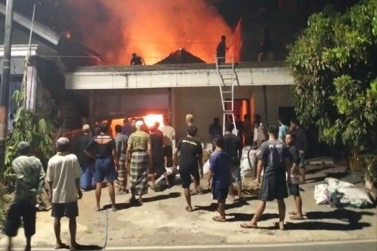 Warga bersama aparat gabungan dan petugas pemadam kebakaran bahu-membahu memadamkan kobaran api yang menghanguskan rumah di Dusun Clumpring, Desa Gemaharjo, Kecamatan Tegalombo, Pacitan, Jawa Timur, Minggu (11/10/2026) malam. (Foto: Istimewa)