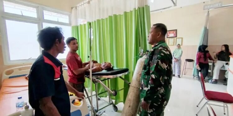 Petugas TNI bersama warga mendampingi Kadiran (70) saat mendapat penanganan medis intensif di Ruang IGD Puskesmas Ngadirojo, Pacitan, usai dievakuasi akibat terperosok ke jurang saat memadamkan kebakaran hutan, Sabtu (10/10/2026). (Foto: Istimewa)